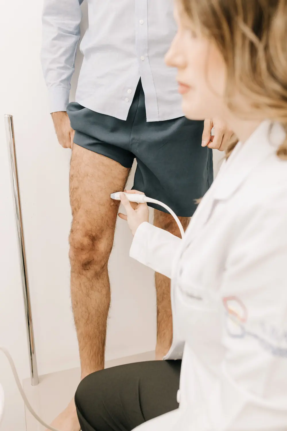 Médica examinando a perna da paciente com ultrassom